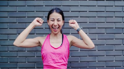 ผู้หญิงใส่เสื้อกีฬาสีชมพู ยกมือ ดูแข็งแรงสดใส ครอปมุมใกล้